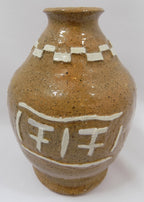 Brown ceramic vase with white decorative elements on a white background
