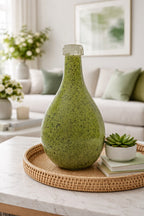 Green textured vase on a coffee table with a living room background