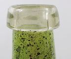 Green glass bottle with a speckled pattern on a white background closeup of top