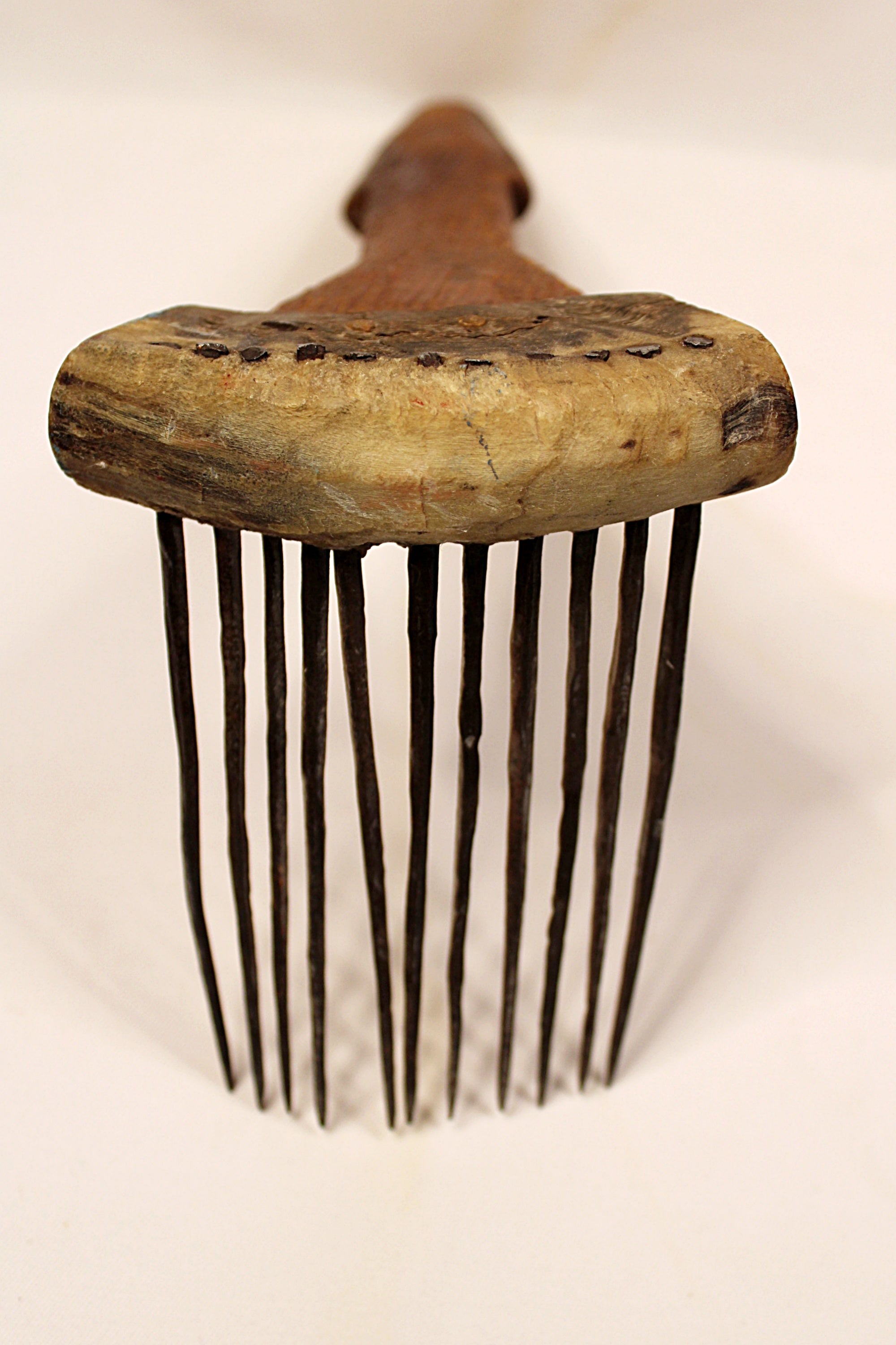 Vintage wooden comb with metal teeth on a white background
