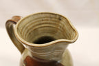 Close-up of a ceramic pitcher with a handle on a light background Rim View-by Bill Heyduck