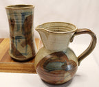 Stonewear vase and pitcher by bill heyduck in 1993 vase sitting on wood tray with white background