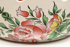 Decorative ceramic dish with floral patterns on a white background