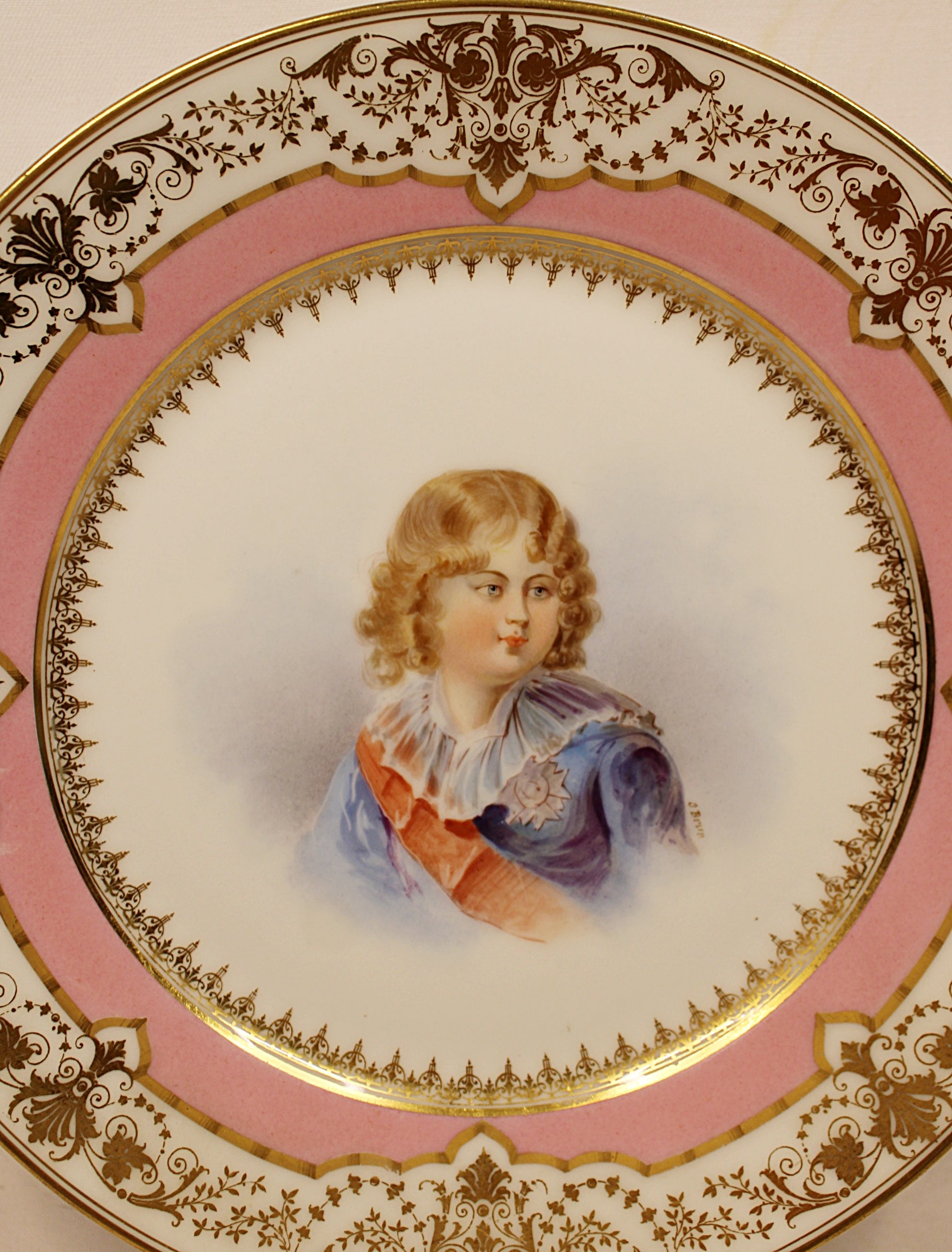 Decorative plate with a portrait of a child on a pink background center closeup