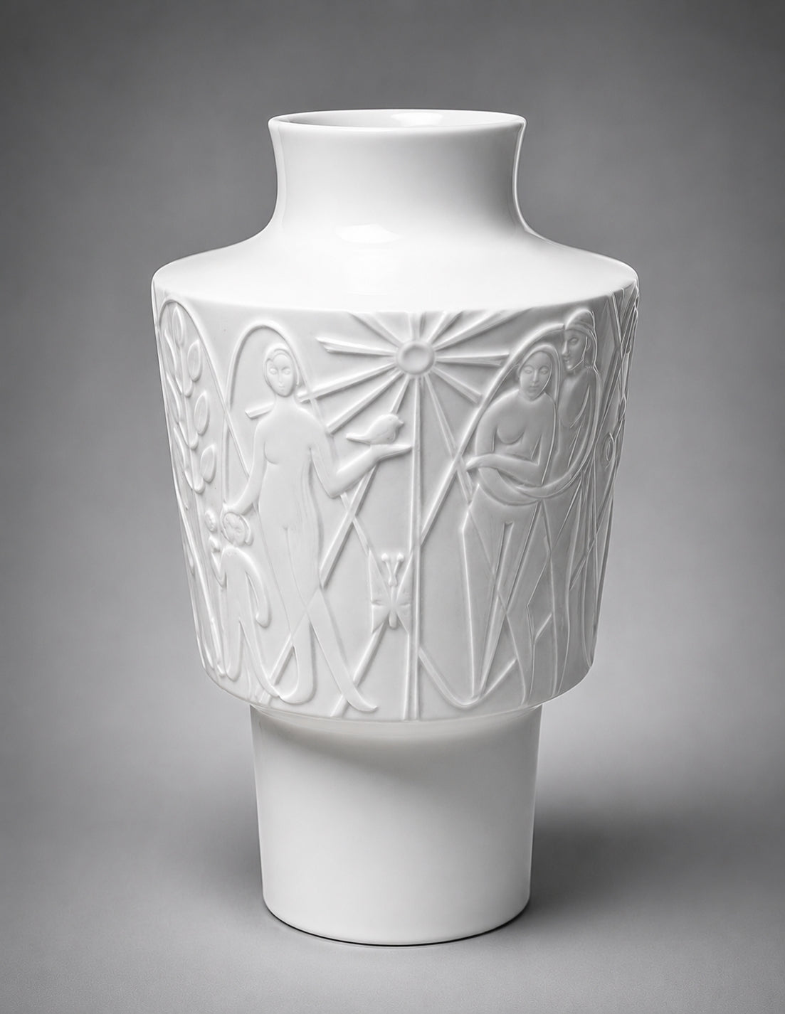 White ceramic vase with artistic embossed designs on a gray background