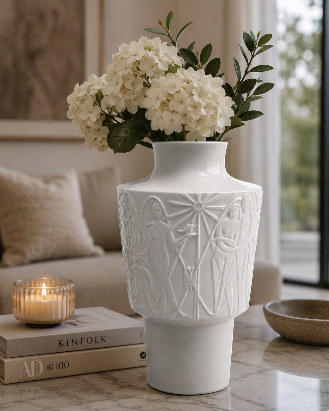 White decorative vase with floral arrangement on a table in a living room setting