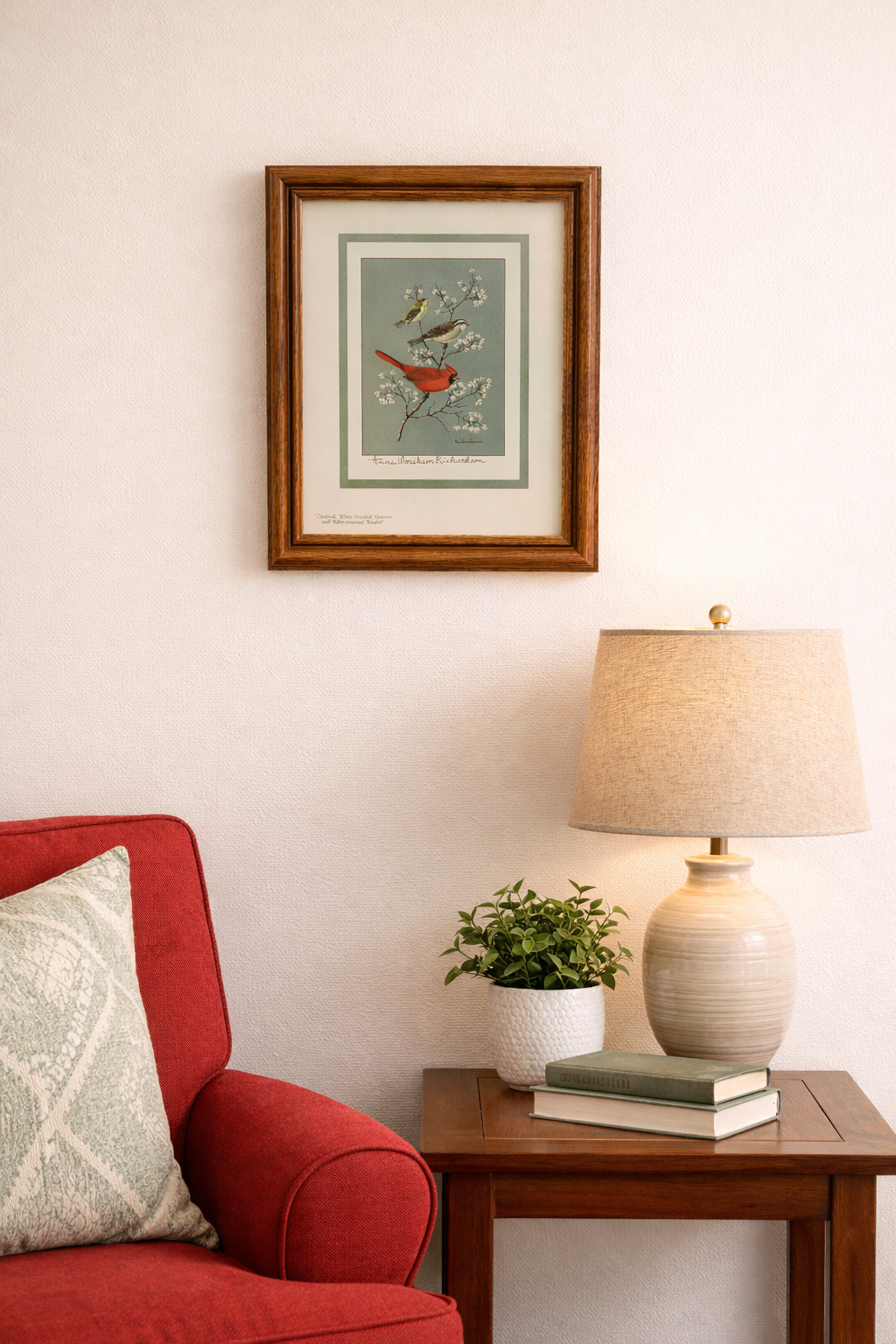 Living room corner with red sofa, wooden side table, lamp, and framed artwork -Framed  Lithograph Three Birds by Anne Worsham Richardson - Charleston Bird Lady