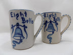 Two ceramic mugs with blue bell design and 'Eight Bells' text on a white background