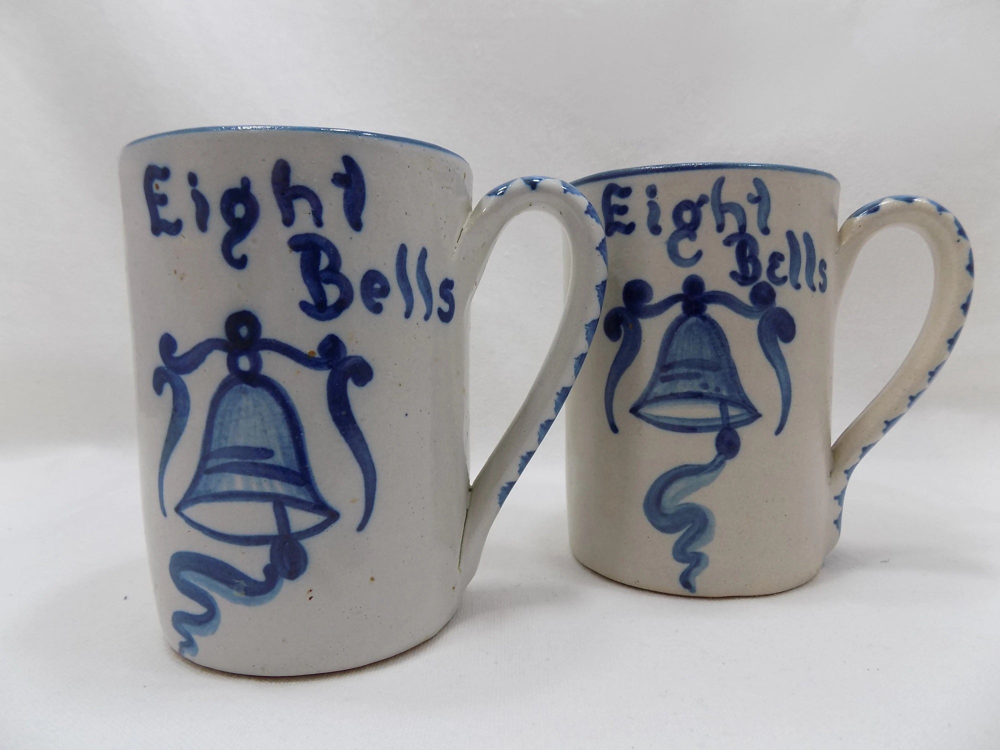 Two ceramic mugs with blue bell design and 'Eight Bells' text on a white background