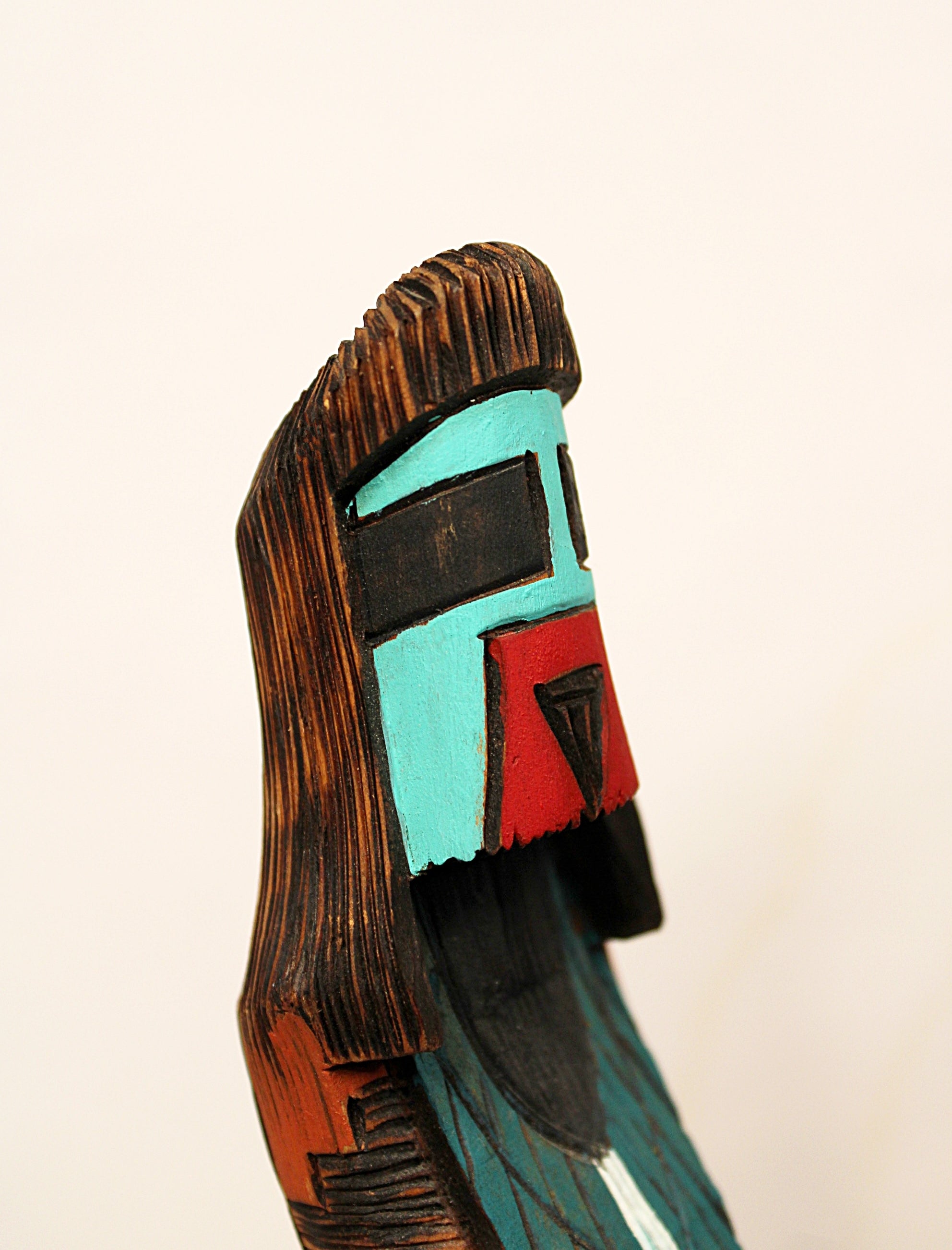 Wooden mask with colorful face on a beige background