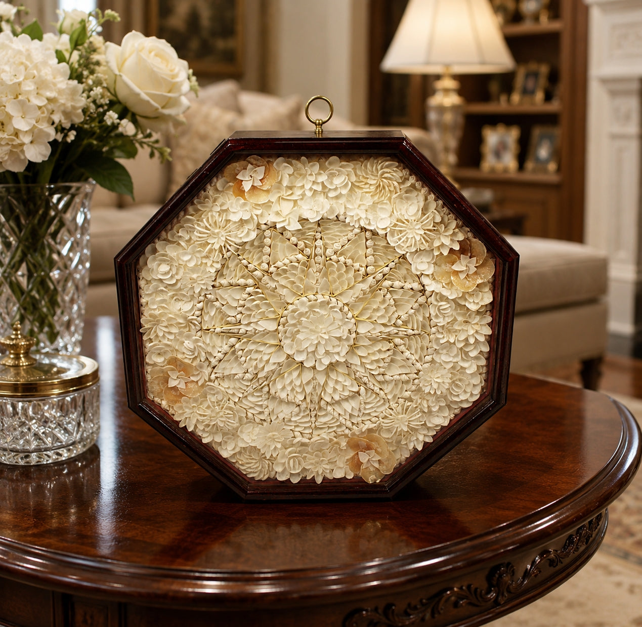 Decorative Sailor's Valentine Handmade with Seashells with Mahogany Frame wall art with floral design on a wooden table in a living room setting.