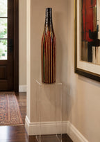 Tessuto Tall decorative vase on a clear pedestal in a entrance  room with a painting on the wall.