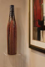 Decorative vase on a clear stand with abstract art in the background